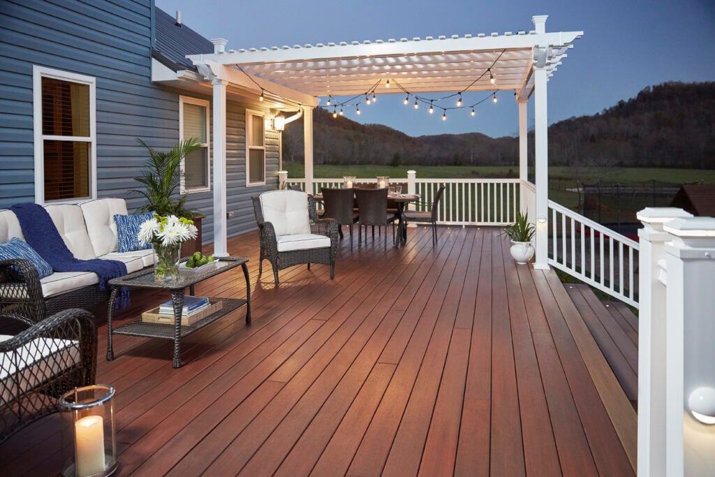 white wooden pergola on a wooden deck with chairs and lights